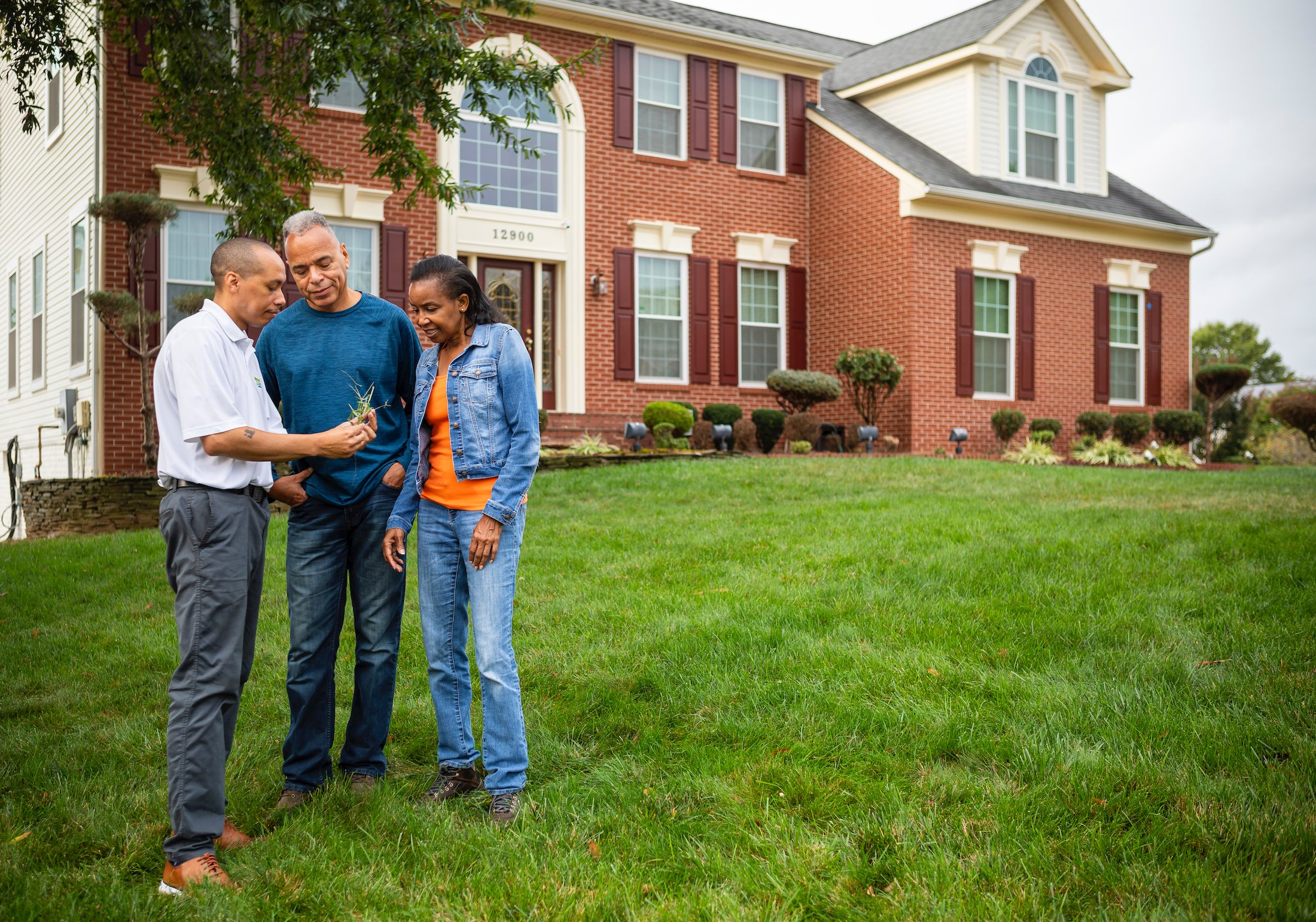 Lawn care technician discussing lawn care with customers