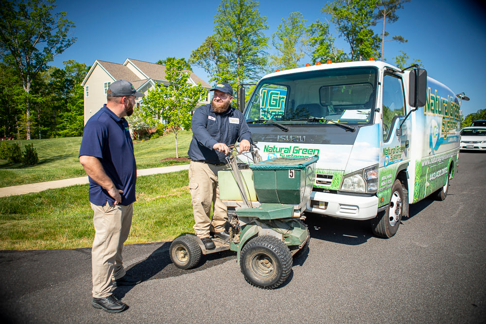 lawn care technicians prepare fertilizer spreader