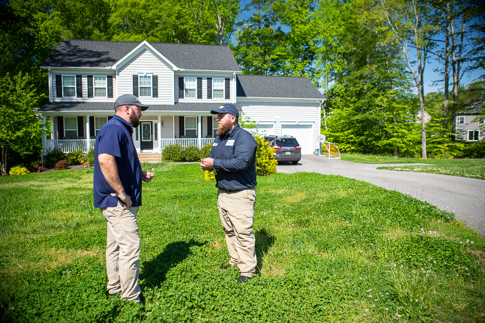 lawn care technician inspecting weeds