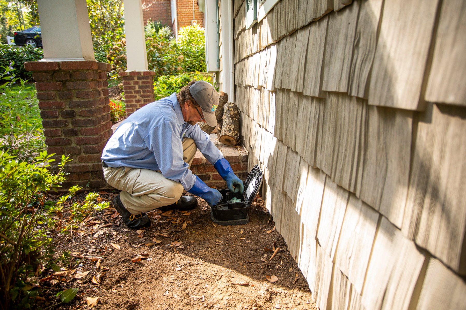 Pest control technician setting up mouse trap