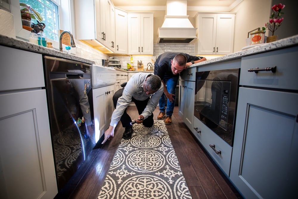 Pest Control technician at natural green inspects home for pests with customer