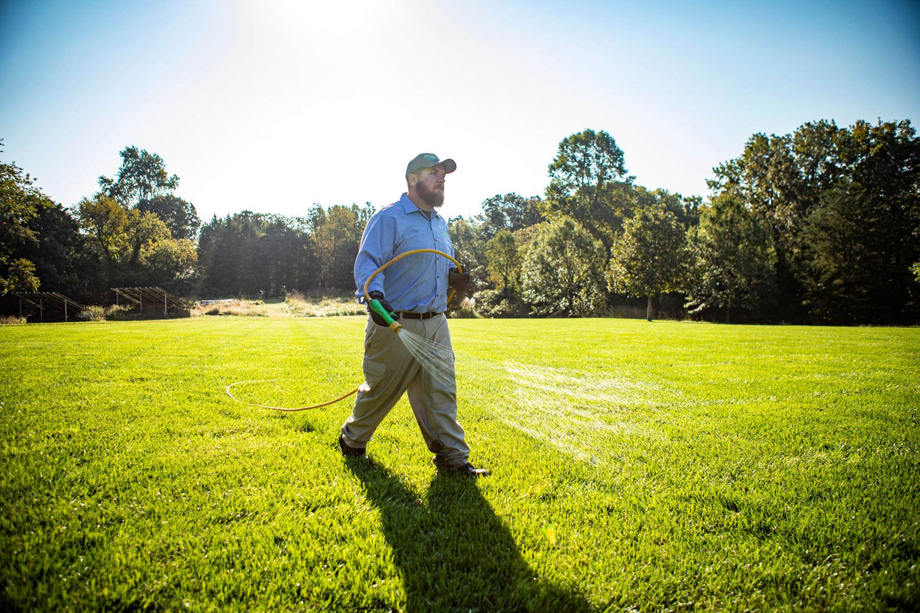 NaturalGreen lawn care technician spraying weed control 