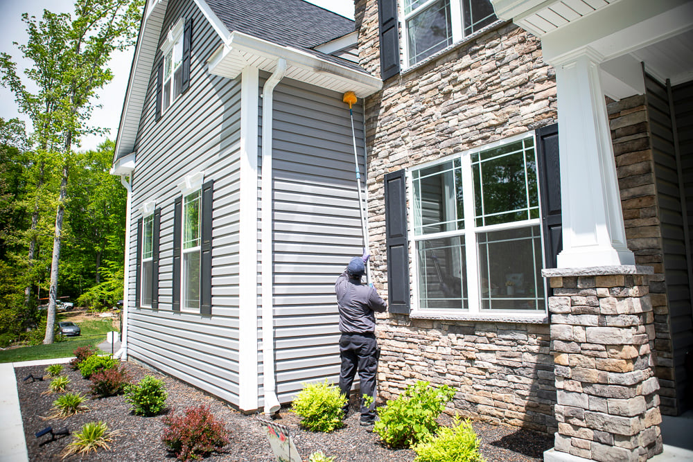 Perimeter pest control team web dusting a house