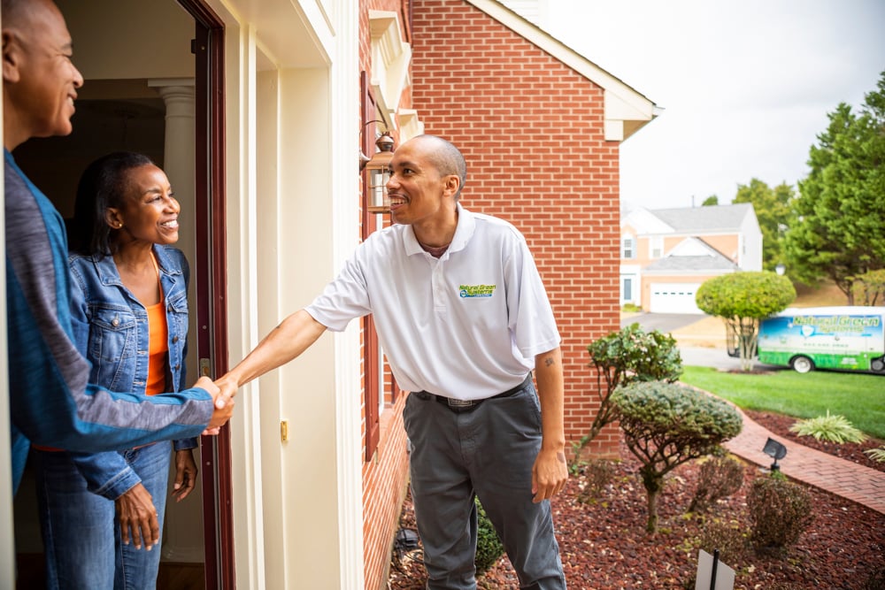 pest control technician meets and shakes hands with clients