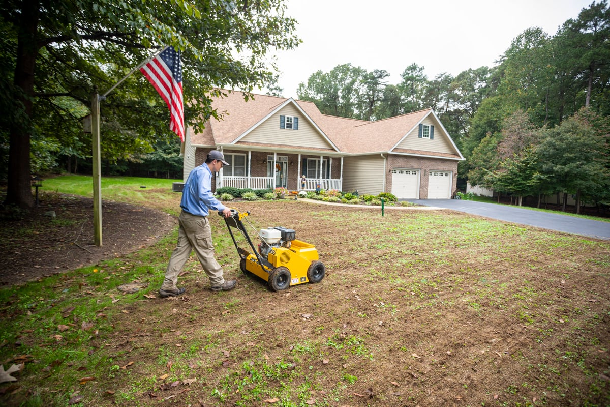 lawn care technician aerates lawn