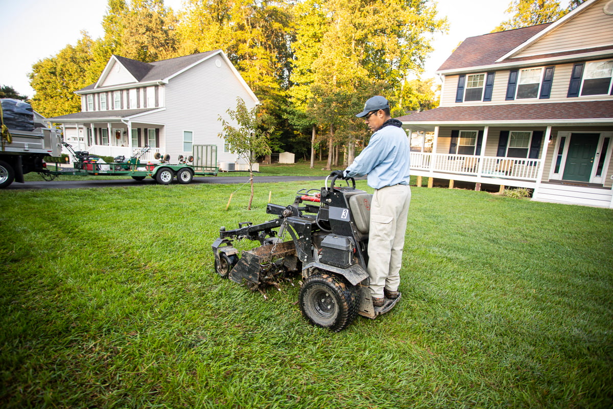 lawn care technician aerates lawn