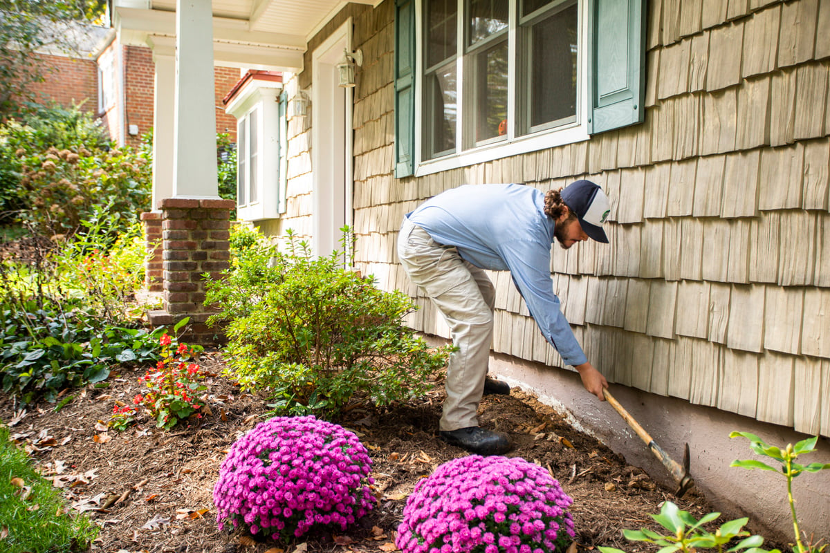 pest control technician digs trench to kill termites