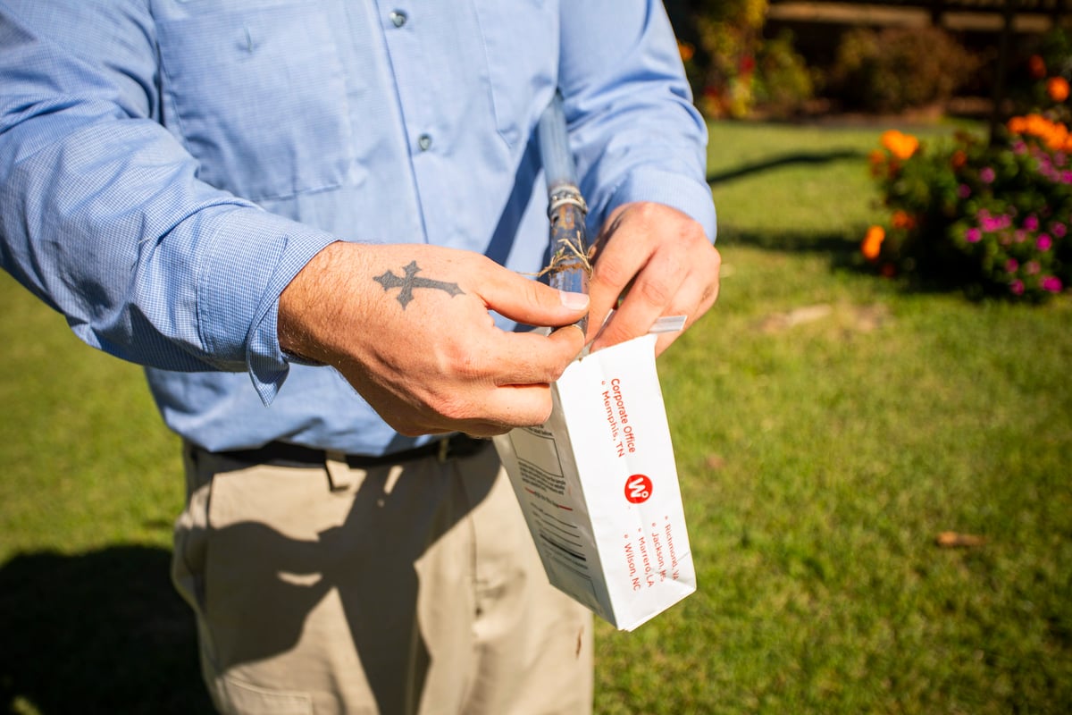 lawn care technician puts soil sample in bag