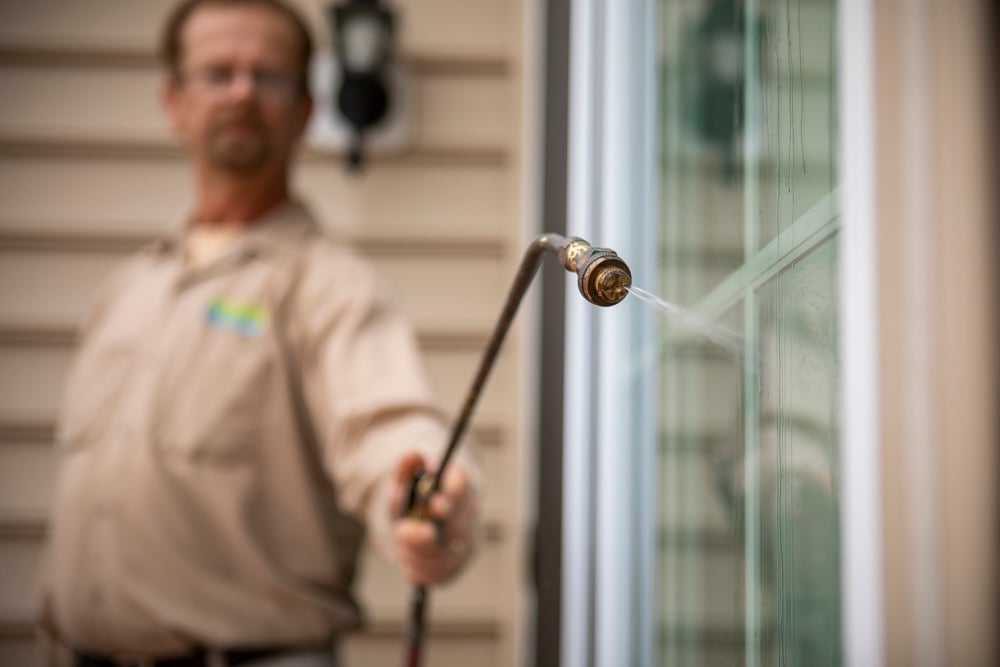 pest control technician holds out small nozzle