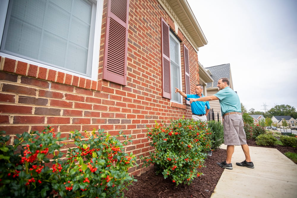 pest control expert inspects outside of home