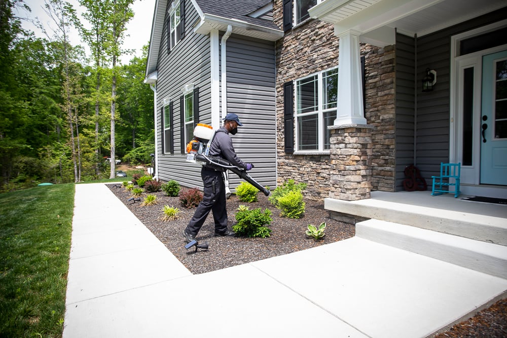 mosquito control technician sprays near patio