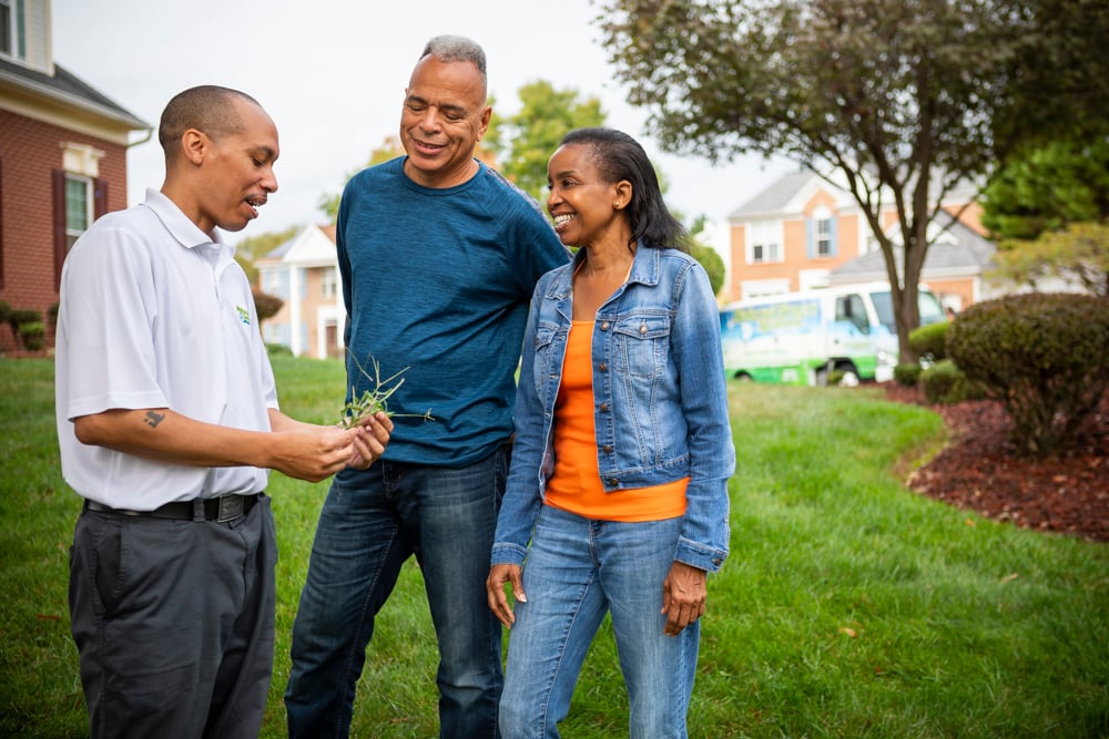 Natural Green lawn care service technician with customers