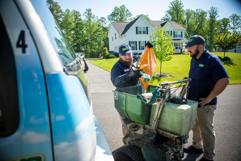 Lawn technicians prepare to fertilize grass