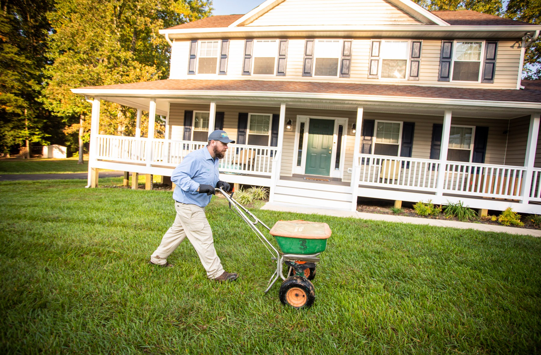 Lawn care technician applying grub control